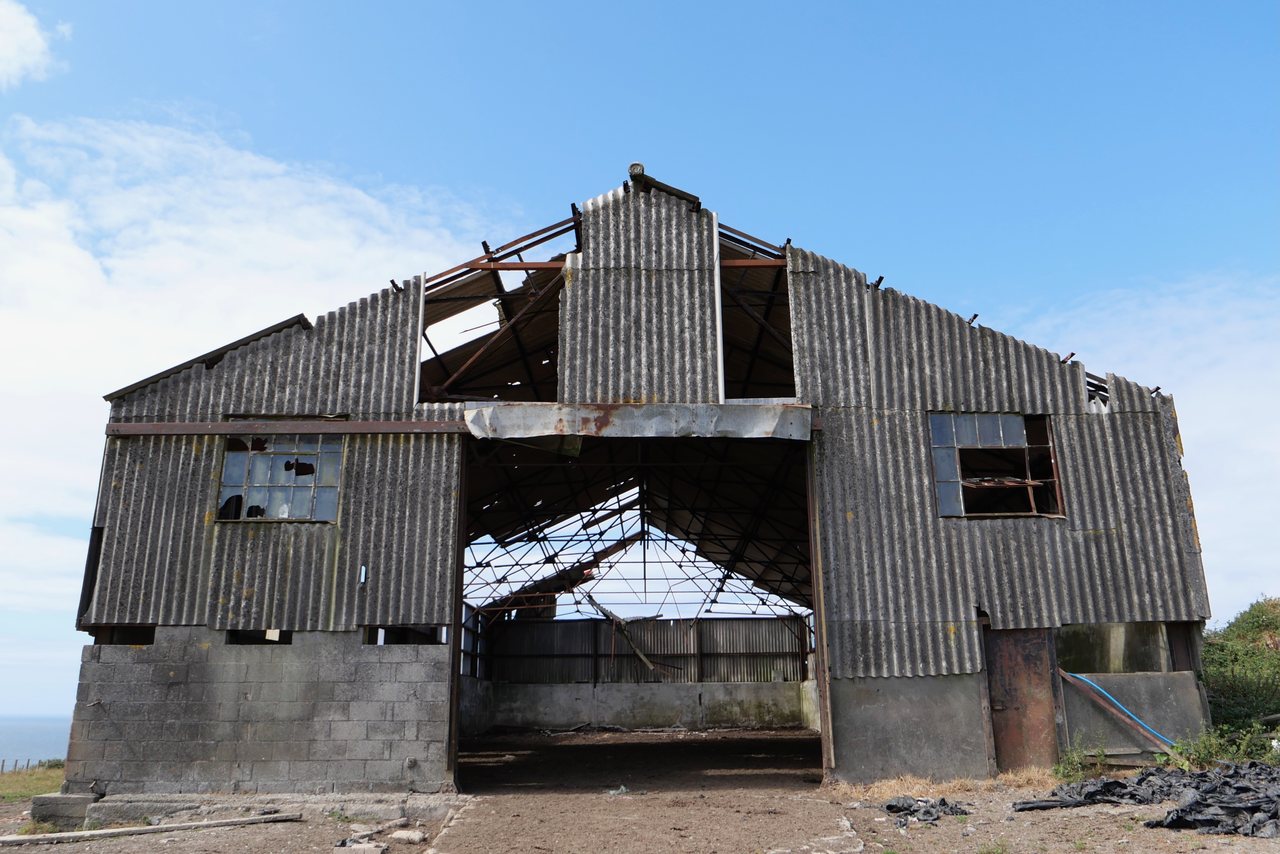 Barn. An old barn with its roof falling in.