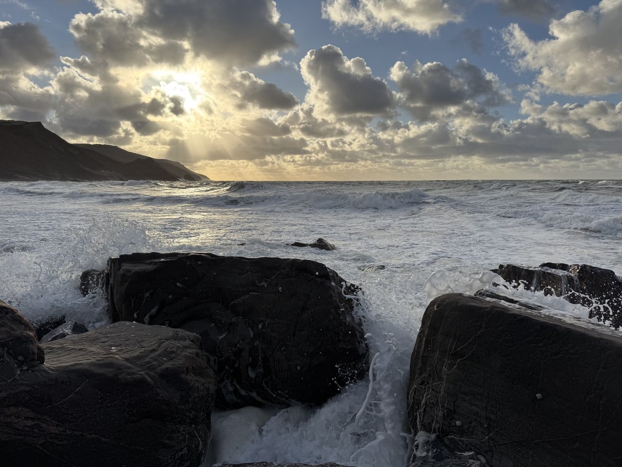 Low Sun. Sun breaking through the cloud over a rough sea.
