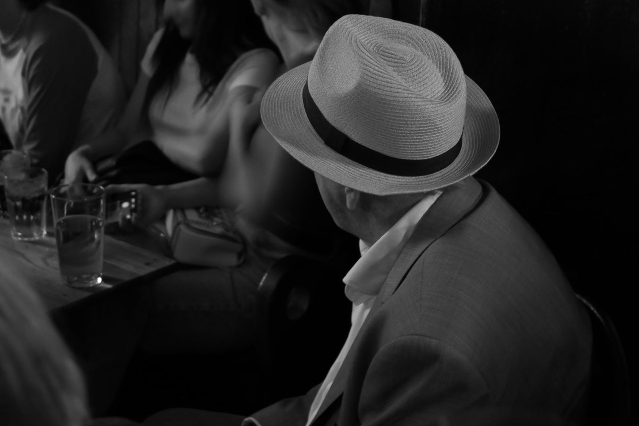 The Hat. A straw hat catches the only light in the room.