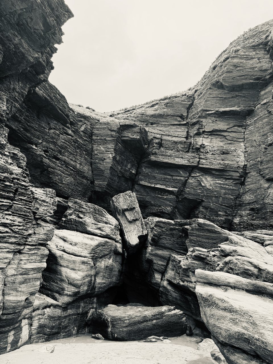The Wedge. A boulder caught in the cliff above a cave.